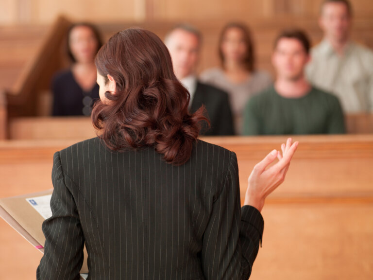 Female lawyer talking to a jury in medical malpractice case.