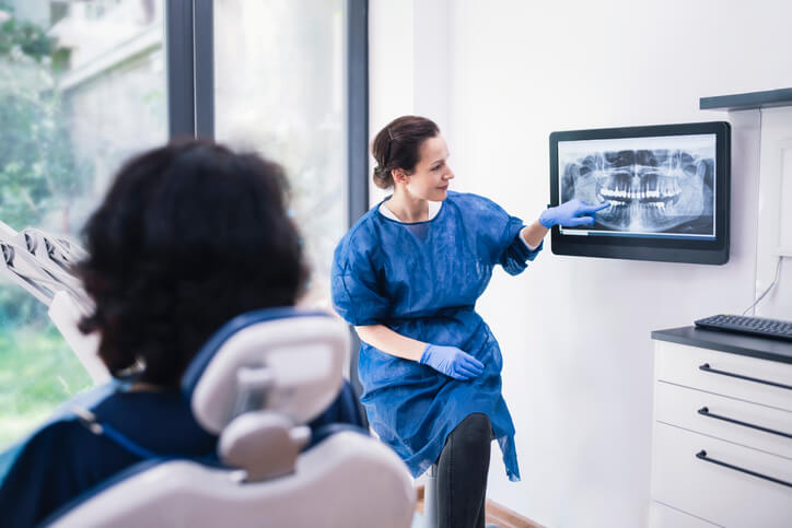 Dentist pointing out x-ray to patient