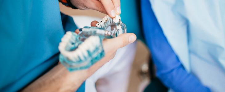 Surgeon holding a dental bridge in his hand