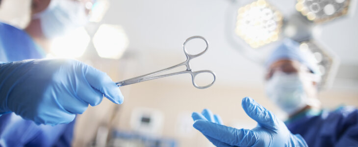 Low angle view of hands of doctor surgeon nurse passing medical equipment tool in surgery operating room hospital